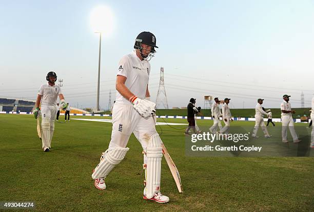 Joe Root and Ian Bell of England leave the field after bad light stops play on day five of the 1st Test between Pakistan and England at Zayed Cricket...