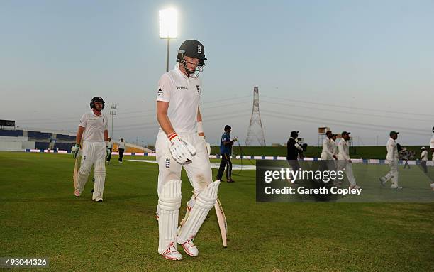 Joe Root and Ian Bell of England leave the field after bad light stops play on day five of the 1st Test between Pakistan and England at Zayed Cricket...