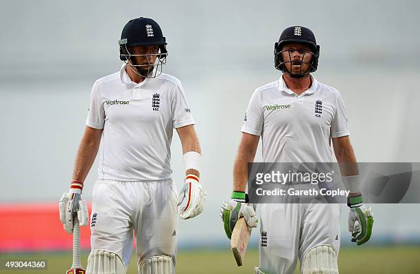 Joe Root and Ian Bell of England leave the field after bad light stops play on day five of the 1st Test between Pakistan and England at Zayed Cricket...