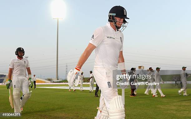 Joe Root and Ian Bell of England leave the field after bad light stops play on day five of the 1st Test between Pakistan and England at Zayed Cricket...