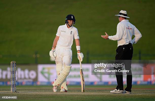 Joe Root of England speaks with umpire Paul Reiffel as the light fades on day five of the 1st Test between Pakistan and England at Zayed Cricket...