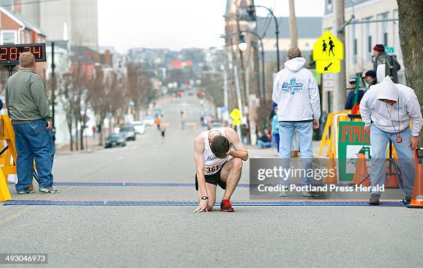 Will Fulford of Kennebunk catches his breath after crossing the finish line for fifth-place during the 84th Boys and Girls Club Patriots Day 5-mile...