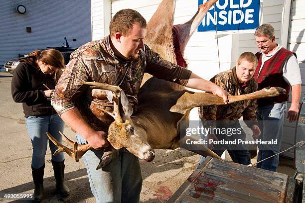 Unity College Conservation Law Enforcement student Gary Proulx swings a 216 lb buck, tethered to the scale, back into the truck at the truck after...