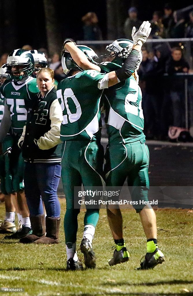 Bonny Eagle High School teammates Ben Malloy, left, and Jon Woods celebrate after Woods dove into th