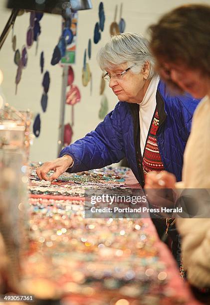 June O'Donnell of Gray looks at pieces of hand-crafted jewelry, created by Crafty Scotts in Sabattus, while shopping with friend Gailyn...