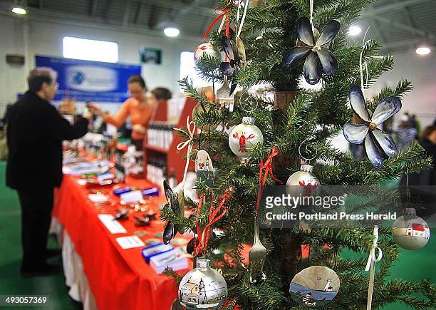 Hand-painted and crafted ornaments with Maine motifs, made by Tina Quattrucci of Saco, attract shoppers at a holiday craft fair at the Stevens Avenue...
