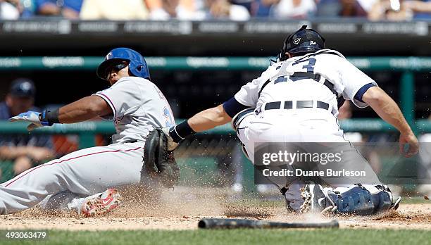 Adrian Beltre of the Texas Rangers beats the tag from catcher Alex Avila of the Detroit Tigers to score in the third inning at Comerica Park on May...