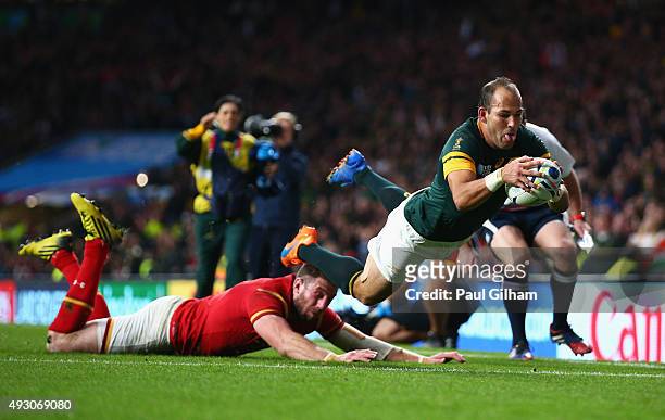 Fourie Du Preez of South Africa scores a try despite the diving tackle of Alex Cuthbert of Wales during the 2015 Rugby World Cup Quarter Final match...