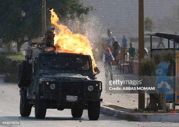An Israeli security forces jeep ignites as Palestinian protesters throw a Molotove cocktail at it during clashes near the Beit El settlement on the...