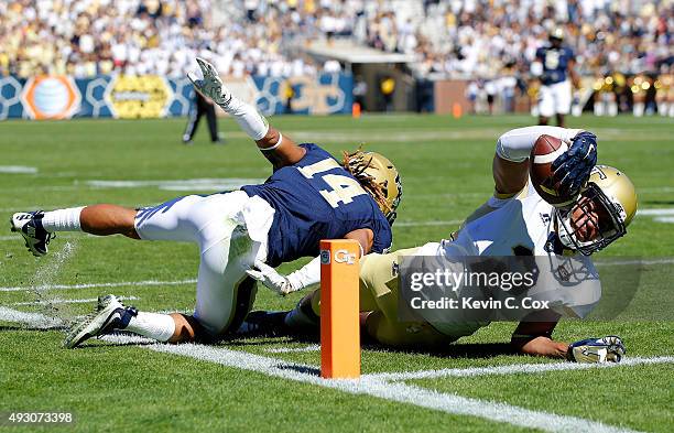 Ricky Jeune of the Georgia Tech Yellow Jackets scores a touchdown as he dives into the end zone away from Avonte Maddox of the Pittsburgh Panthers at...