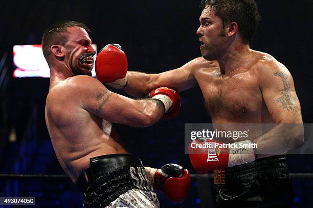 Jimmy Lange punches the mouthpiece out of the mouth of Mike Sawyer during their light heavyweights bout at EagleBank Arena on the campus of George...