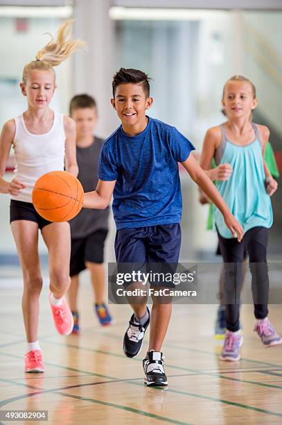 kinder spielen sie basketball im fitnessraum - girl in gym stock-fotos und bilder