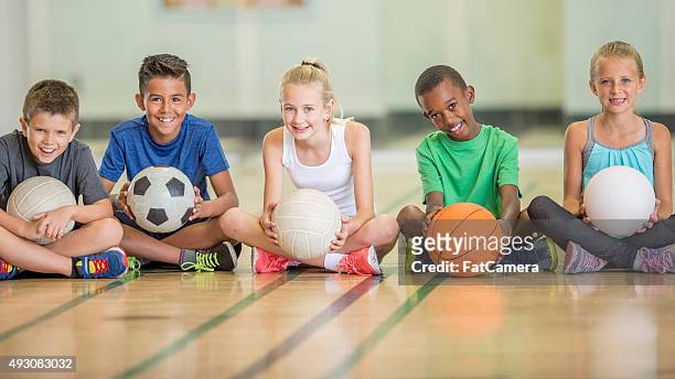kids sitting at the gym - basketbal bal stockfoto's en -beelden