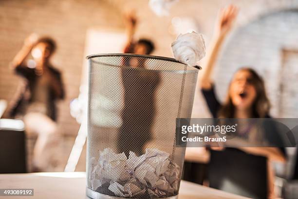 throwing crumpled paper into a wastepaper basket. - throwing stock pictures, royalty-free photos & images