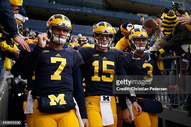 Quarterbacks Shane Morris, Jake Rudock and Wilton Speight of the Michigan Wolverines take the field for warm ups to the college football game against...
