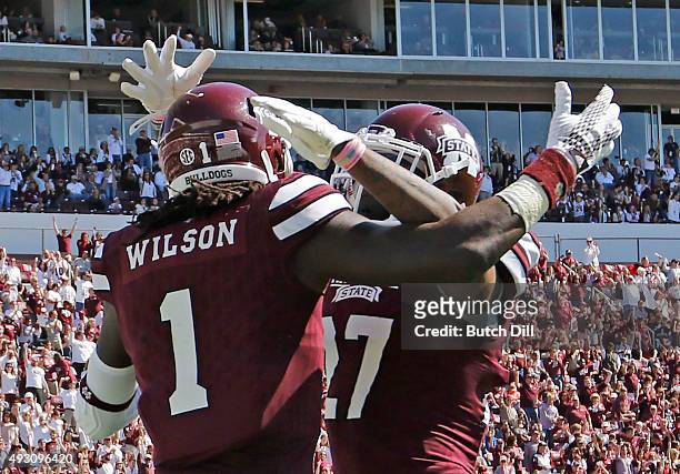 Wide receiver De'Runnya Wilson celebrates with running back Aeris Williams of the Mississippi State Bulldogs after he scored a touchdown during the...