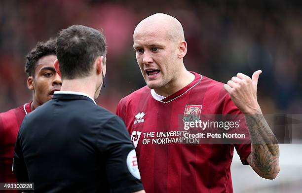 Ryan Cresswell of Northampton Town makes a point to referee Darren England during the Sky Bet League Two match between Cambridge United and...