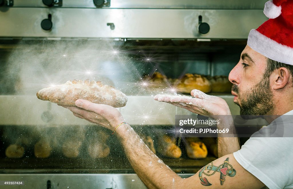 Junger Mann (baker) vergrößert die Mehl auf Brot