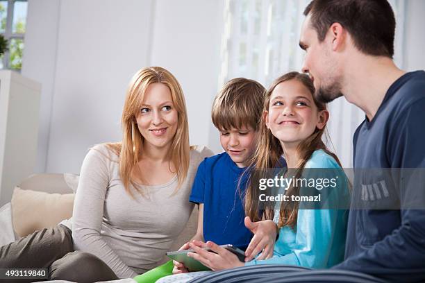familie im bett mit digitalen tablet - boy in pajamas and mom on tablet stock-fotos und bilder