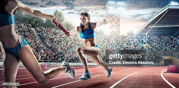 running fahren sie auf dem olympic stadium - staffelstab stock-fotos und bilder