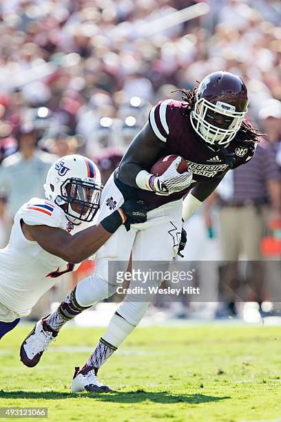 De'Runnya Wilson of the Mississippi State Bulldogs runs the ball and is hit by Lyn Clark of the Northwestern State Demons at Davis Wade Stadium on...