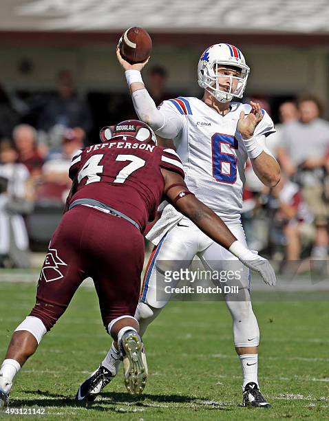 Quarterback Jeff Driskel of the Louisiana Tech Bulldogs throws a pass as he is pressured by defensive lineman A.J. Jefferson of the Mississippi State...