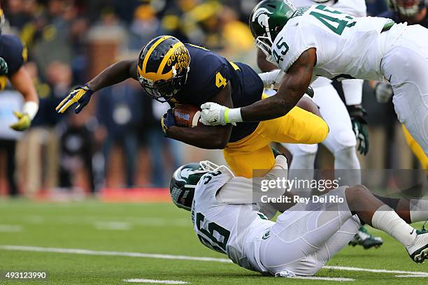 De'Veon Smith of the Michigan Wolverines runs the ball against the Darien Harris of the Michigan State Spartans at Michigan Stadium on October 17,...