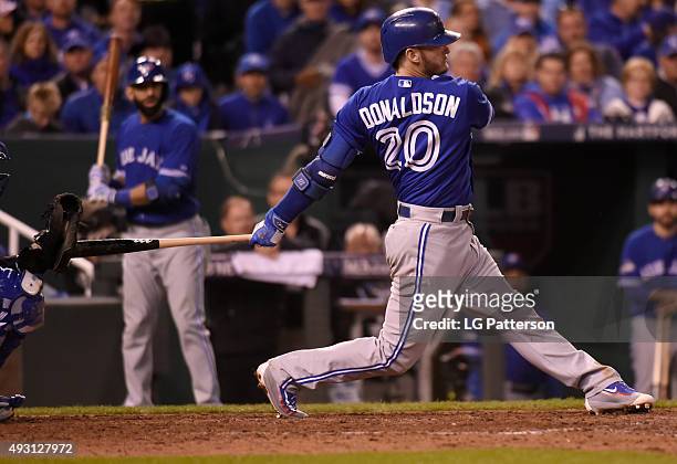 Josh Donaldson of the Toronto Blue Jays hits Salvador Perez of the Kansas City Royals with his bat during his follow through in the top of the eighth...