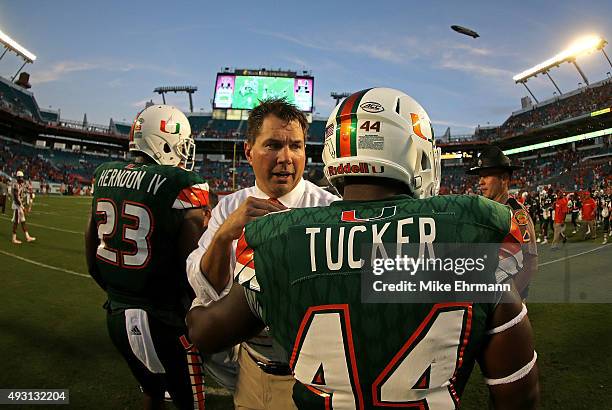 Head coach Al Golden of the Miami Hurricanes congratulates Walter Tucker during a game against the Virginia Tech Hokies at Sun Life Stadium on...