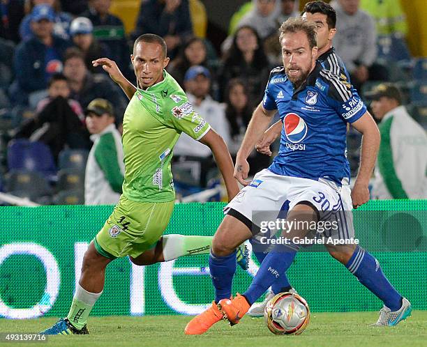 Federico Insua of Millonarios struggles for the ball with Yonaider Ortega of Jaguares FC during a match between Millonarios and Jaguares FC as part...
