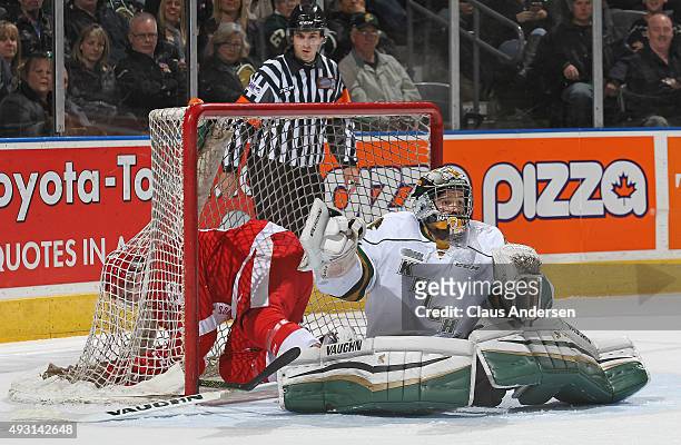 Blake Speers of the Sault Greyhounds ends up in the net behind Tyler Parsons of the London Knights during an OHL game at Budweiser Gardens on October...