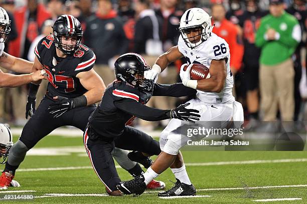 Saquon Barkley of the Penn State Nittany Lions is stopped behind the line on third down by Gareon Conley of the Ohio State Buckeyes and Joey Bosa of...