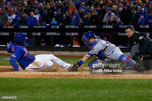 Juan Lagares of the New York Mets slides safe to home plate against Miguel Montero of the Chicago Cubs to score a run off of Curtis Granderson's...