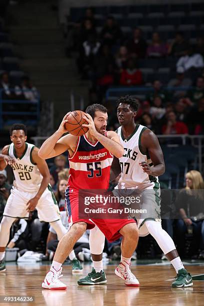 Milwaukee, WI Josh Harrellson of the Washington Wizards handles the ball against Johnny O'Bryant III of the Milwaukee Bucks during a preseason game...