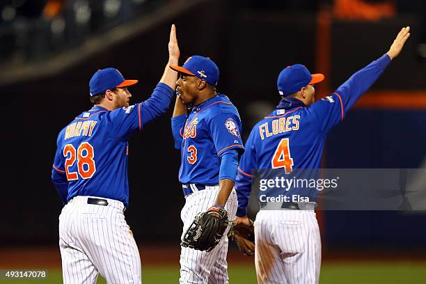 Daniel Murphy, Curtis Granderson and Wilmer Flores of the New York Mets celebrates after defeating the Chicago Cubs by a score outfield 4-2 to win...