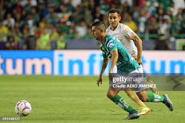 Elias Hernandez of Leon vies for ball with Luis Fuentes of Pumas during their Mexican Apertura tournament football match at the Nou Camp stadium on...