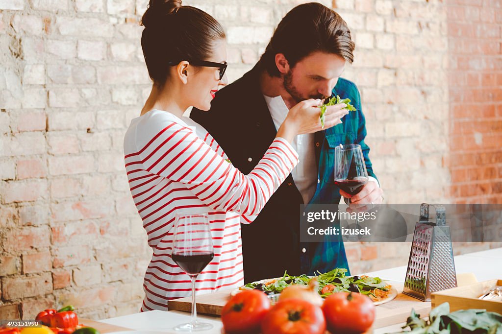Paar bereitet pizza in der modernen Küche, die trinken Wein