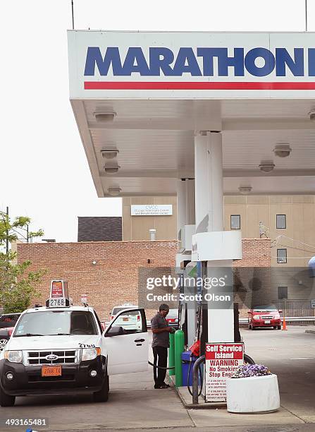 Customer purchases gasoline at a Marathon gas station on May 22, 2014 in Chicago, Illinois. Marathon Petroleum Corp. Has agreed to purchase Hess...