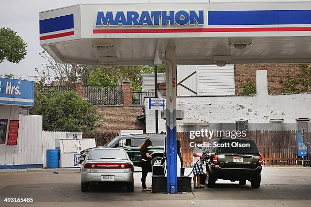 Customers purchase gasoline at a Marathon gas station on May 22, 2014 in Chicago, Illinois. Marathon Petroleum Corp. Has agreed to purchase Hess...
