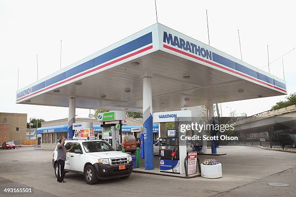 Customer purchases gasoline at a Marathon gas station on May 22, 2014 in Chicago, Illinois. Marathon Petroleum Corp. Has agreed to purchase Hess...