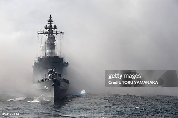 Japan's Maritime Self-Defense Force escort ship Kurama sails through smoke during a fleet review off Sagami Bay, Kanagawa prefecture, on October 18,...