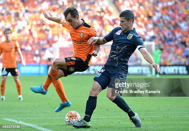 Steven Lustica of the Roar and Nick Montgomery of the Mariners challenge for the ball during the round two A-League match between the Brisbane Roar...