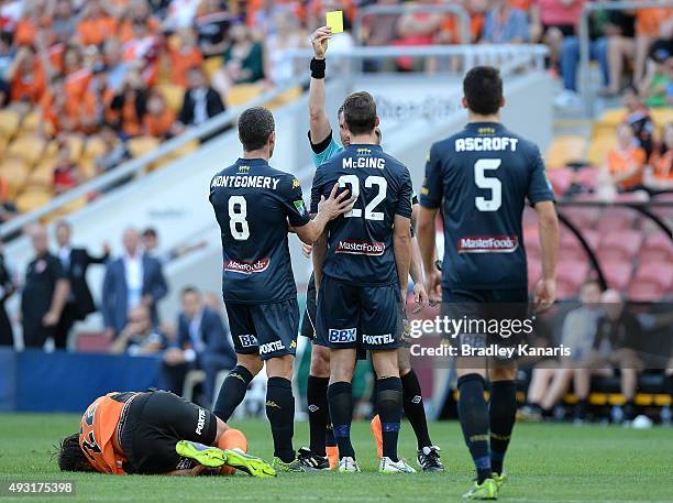 Referee Ben Williams gives out a yellow card to Jake McGing of the Mariners for an illegal tackle on Thomas Broich of the Roar during the round two...