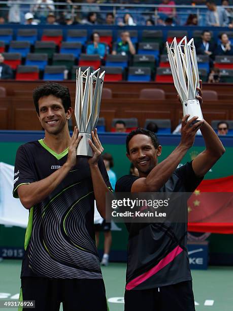 Marcelo Melo of Brazil and Raven Klaasen of Republic of South Africa hold their trophy at the award ceremony after winning the match against Simone...