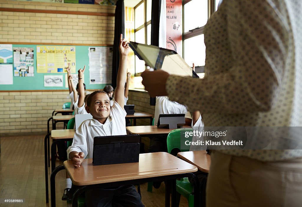 Boy with raised hand in classroom