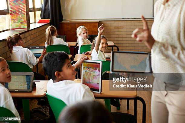 Kids in schoolclass getting taught with tablets