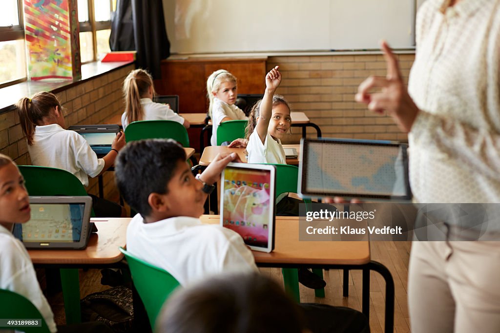 Kids in schoolclass getting taught with tablets