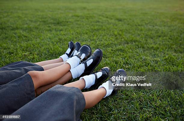 closeup of legs of 3 schoolgirls in uniforms - black skirt stockfoto's en -beelden