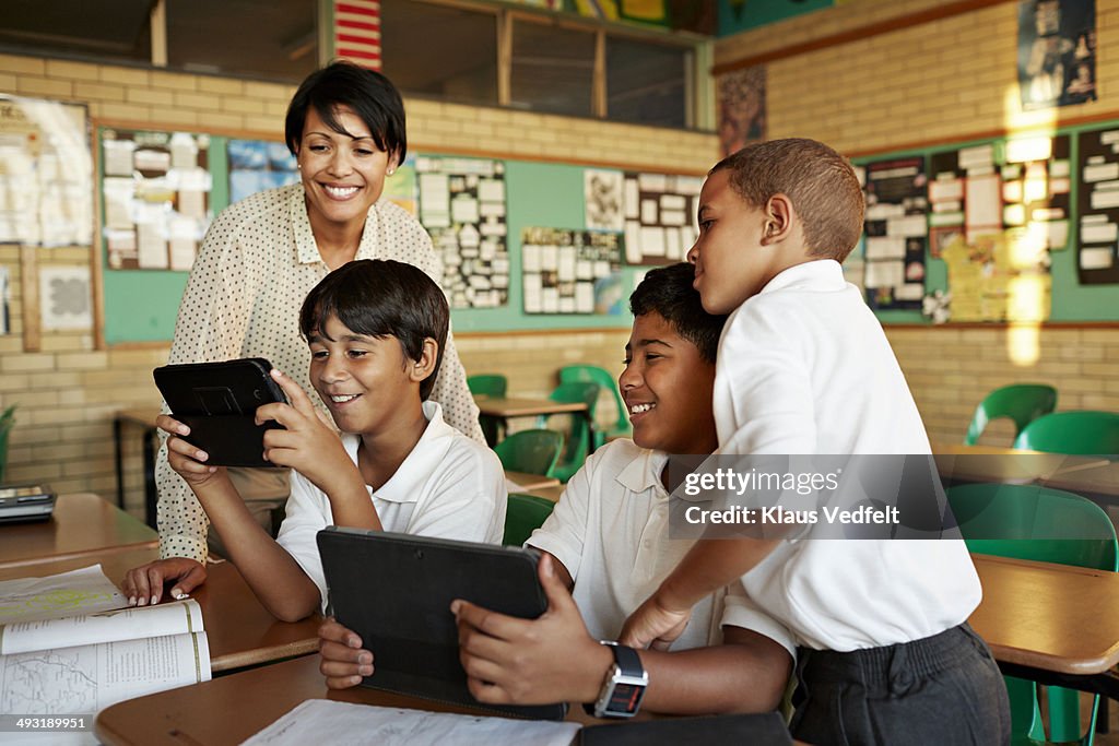 Teacher and students looking at tablet