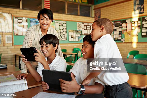 teacher and students looking at tablet - school tablet stockfoto's en -beelden